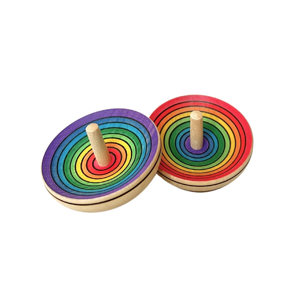 Two rainbow-colored wooden spinning tops on a white background