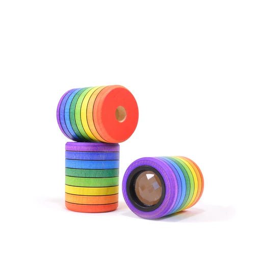 Stack of rainbow-colored cylindrical kaleidoscopes on a white background