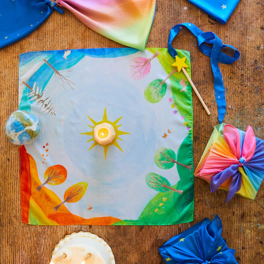 Colorful playsilk with the four seasons on a wood table with silk decorations