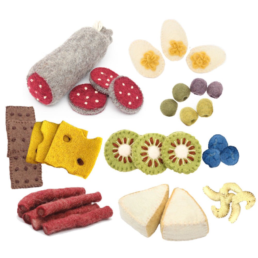  A large selection of felted meats, cheeses, olives, egges, fruits, and crackers on a white background