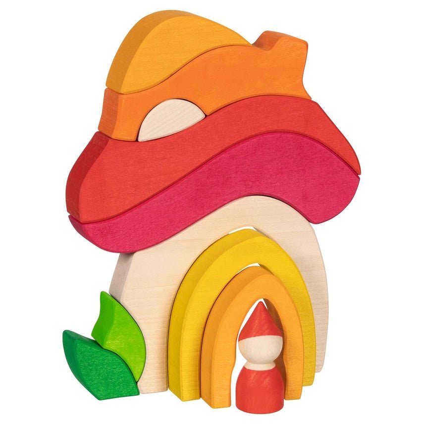 Blocks arranged in the shape of a mushroom house with a wooden peg gnome standing in the door way