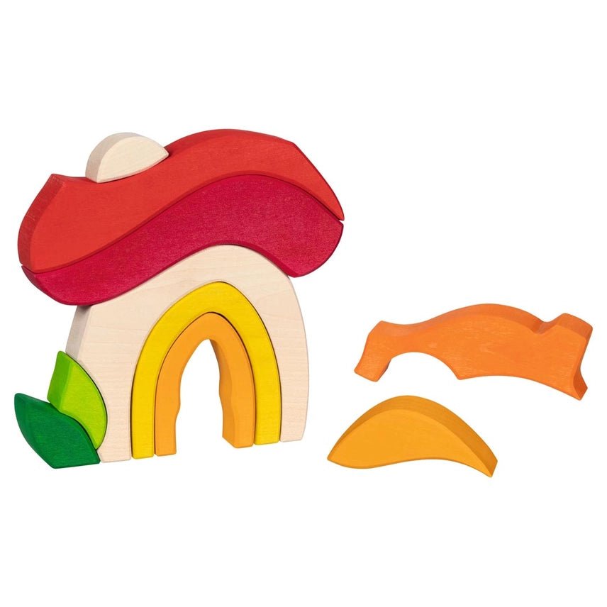 Mushroom shaped house made of diffently shaped blocks to the side on a white background