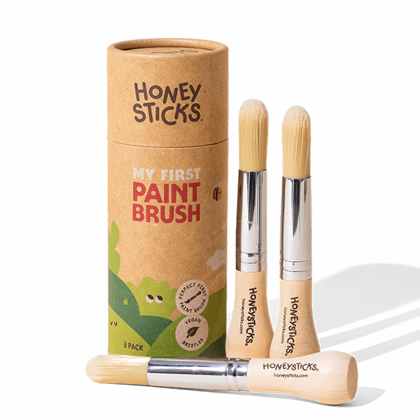 Three paint brushes with a cardboard tube labeled 'Honeysticks' on a white background