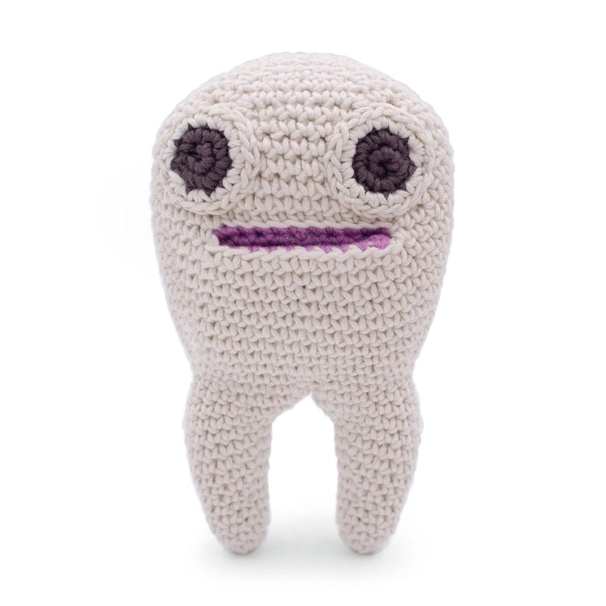 Crocheted tooth with two large eyes and a mouth on a white background