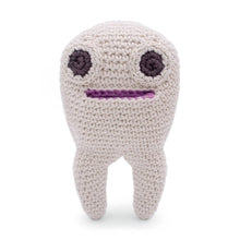 Crocheted tooth with two large eyes and a mouth on a white background