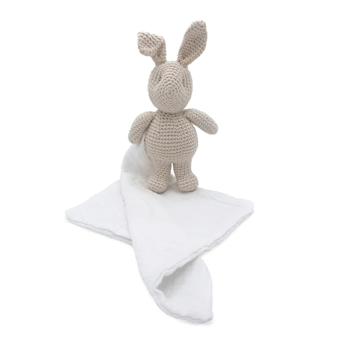 Crocheted rabbit toy with a white blanket on a white background