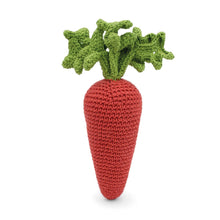 Crocheted carrot toy with green leaves on a white background