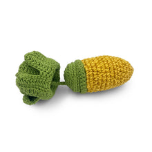 Knitted toy resembling a corn cob and leaves on a white background