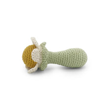 Knitted baby rattle of white flower with a yellow center on a white background