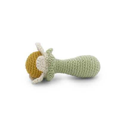 Knitted baby rattle of white flower with a yellow center on a white background