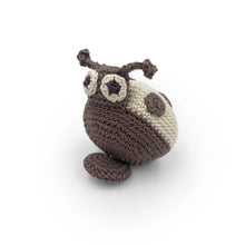Crocheted beige and gray ladybug toy with a pull-string on a white background