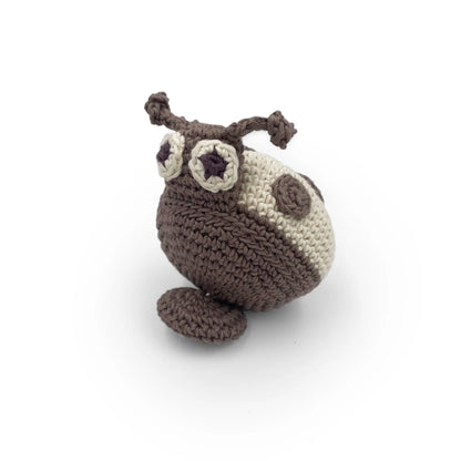 Crocheted beige and gray ladybug toy with a pull-string on a white background