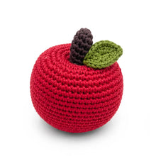 A crocheted apple rattle in bright red with a dark brown stem and a green leaf, shown on a clean white background.