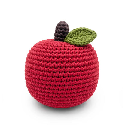 Crocheted red apple rattle with green leaf and brown stem on a white background