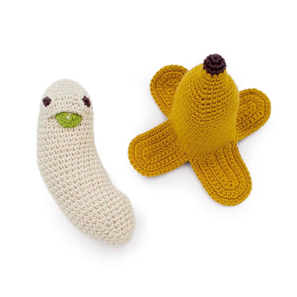 Crocheted banana toy and peel on a white background