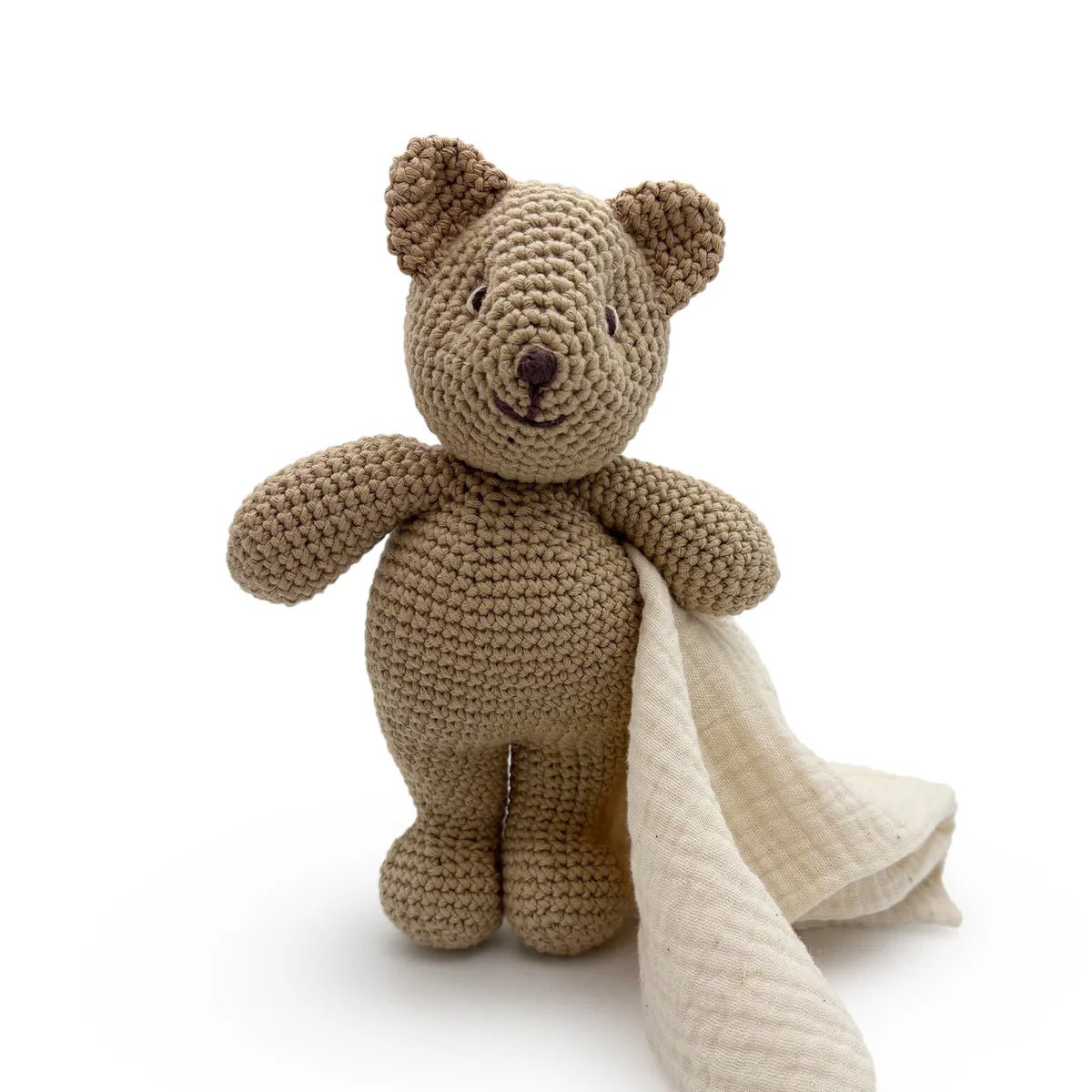 Crocheted bear toy with a blanket on a white background