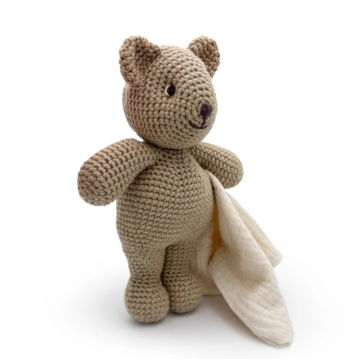 Crocheted teddy bear with a blanket on a white background