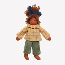 Doll with brown skin wearing a yellow checkered coat and green pants on a white background