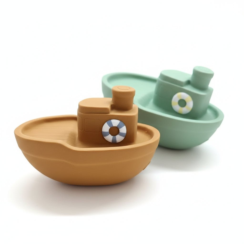 Two rubber boat bath toys, one green and one brown, on a white background