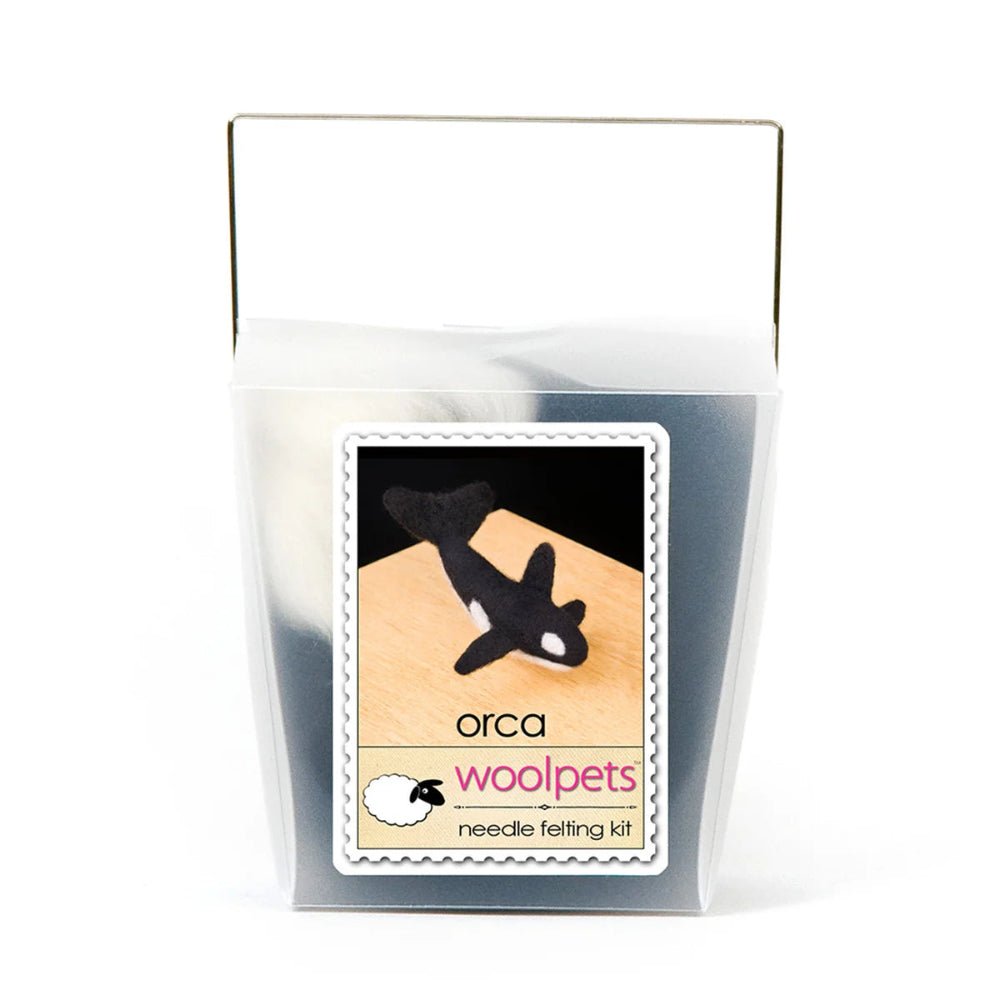 Frosted plastic box with materials to make a needle felted orca with woolpets branding on a white background