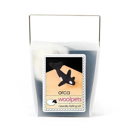 Frosted plastic box with materials to make a needle felted orca with woolpets branding on a white background
