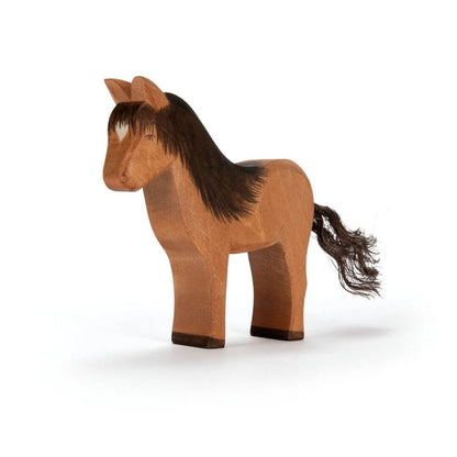 Wooden figurine of a brown Icelandic horse on a white background