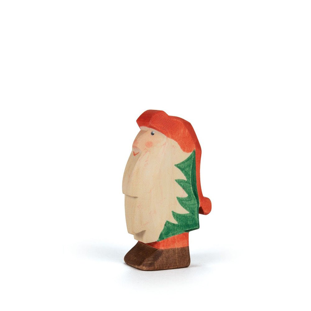 Wooden gnome figurine with a red hat and pants, green coat, and long white beard on a white background