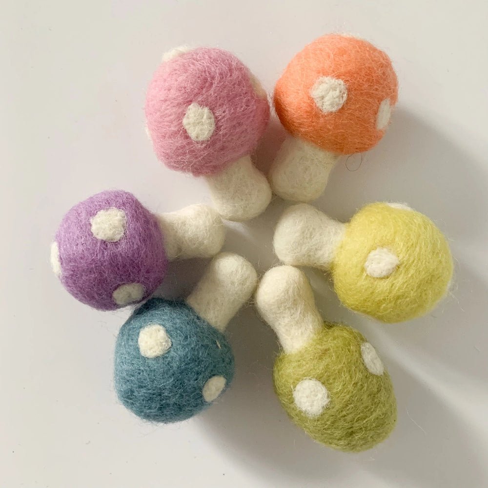 Colorful felt mushrooms on a white background