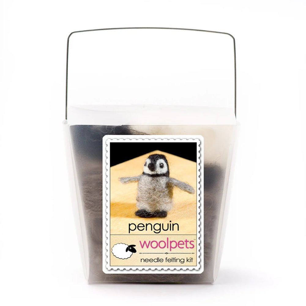 Frosted plastic box containing materials for a needle felted penguin with woolpets branding on a white background