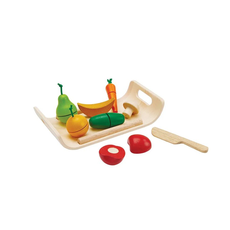 Set of colorful toy fruits and vegetables on a wooden tray with a knife on a white background