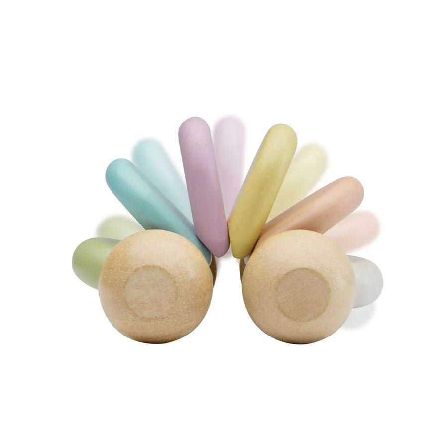 Demonstration of flexiblilty of Plan Toys pastel baby car on a white background