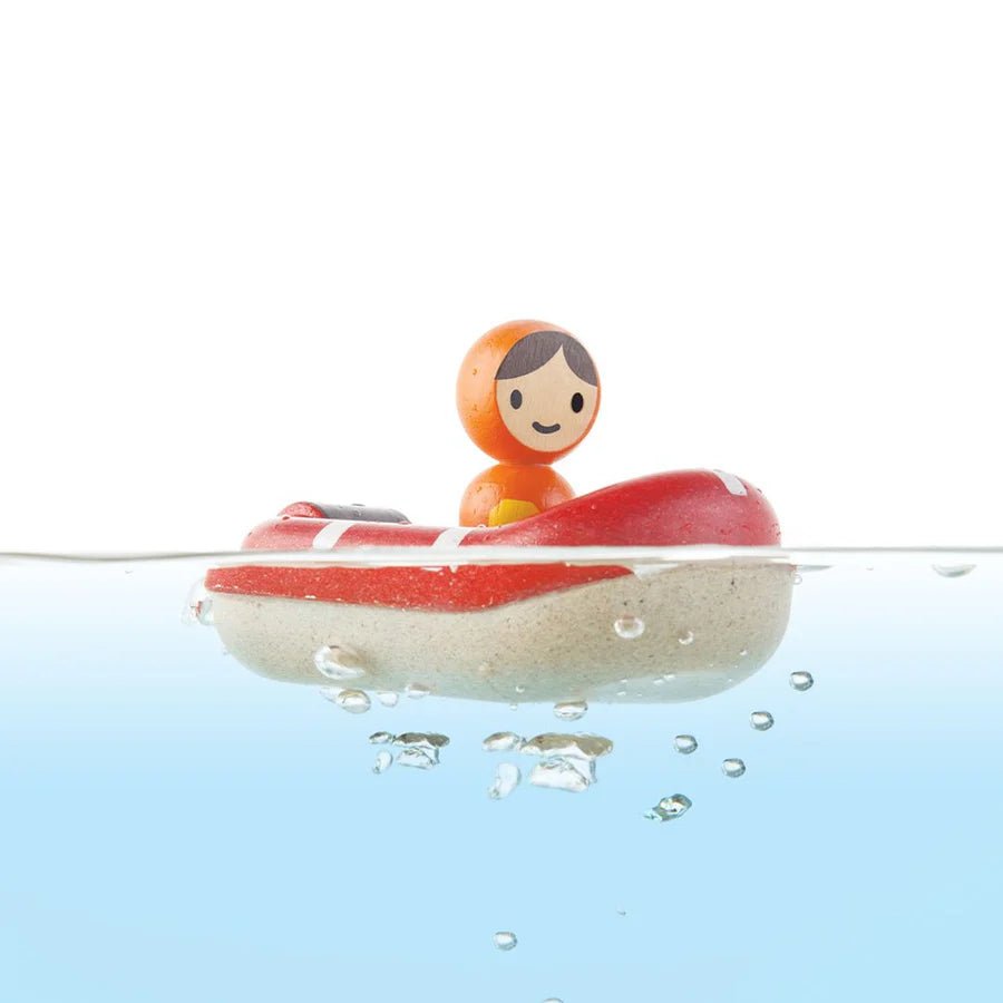 Small figurine in a red boat on water with a white background