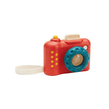 Red toy camera with a blue lens on a white background