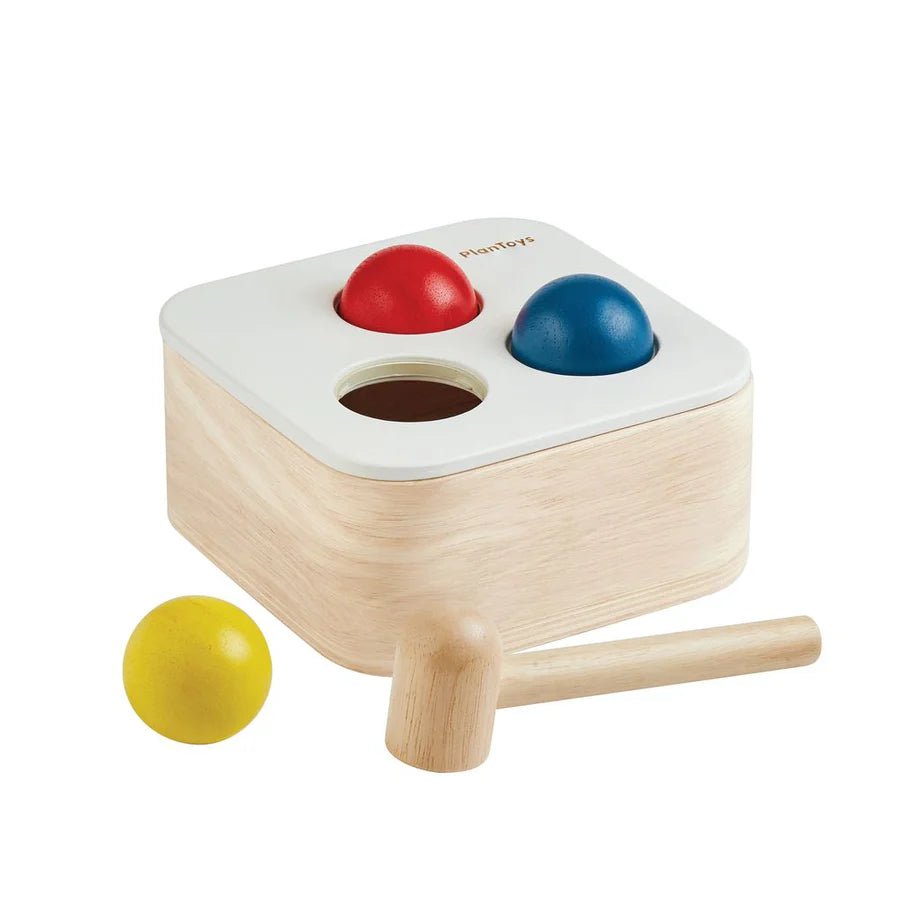 Wooden toy with colorful balls and a mallet on a white background