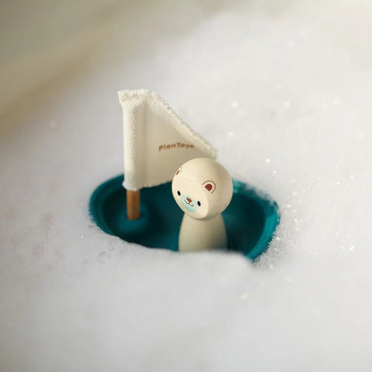 Small toy sailboat with a polar bear figure in a bubble bath