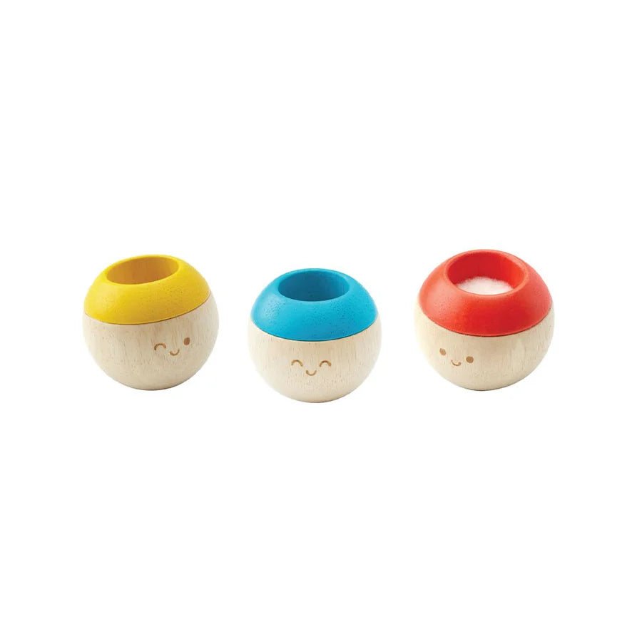 Three small wooden tumbling toys on a white background