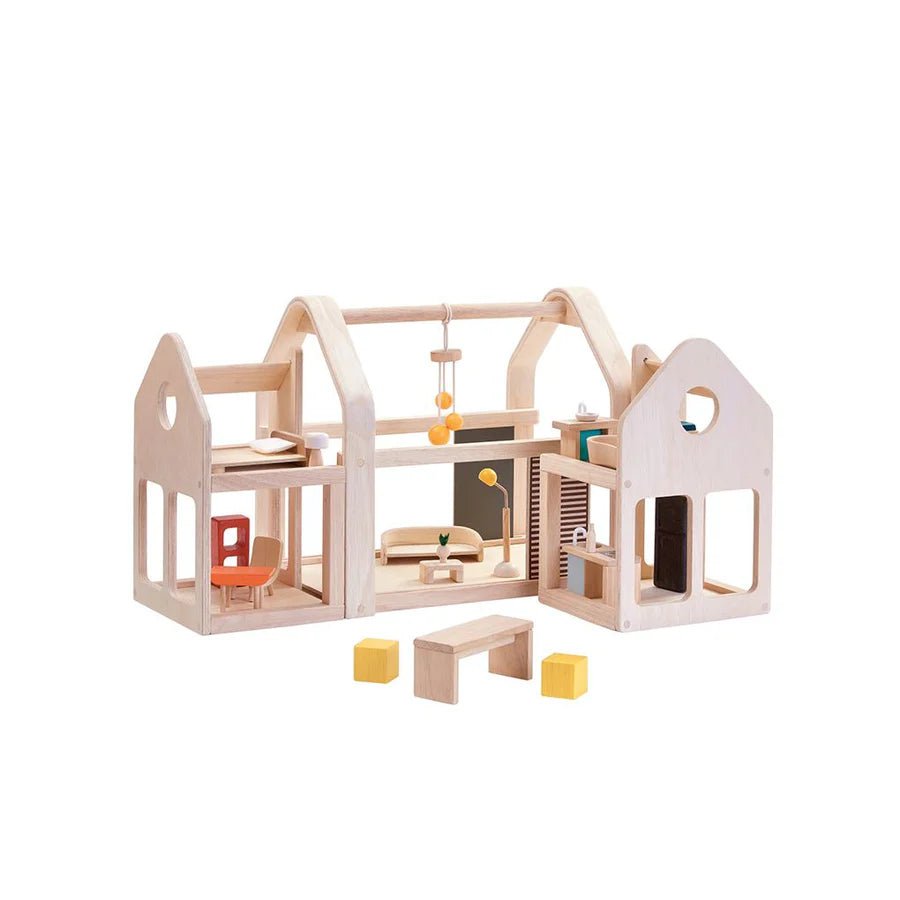 Wooden dollhouse with furniture on a white background