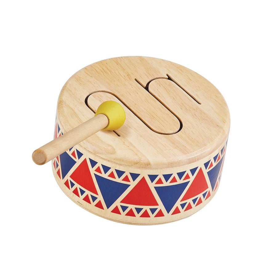 Wooden toy drum with colorful patterns and a yellow handle on a white background