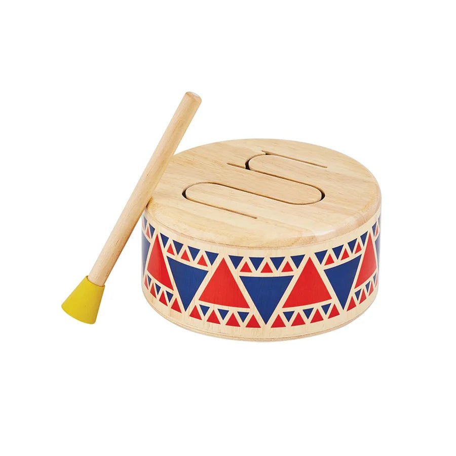 Wooden drum with geometric pattern and drumstick on a white background