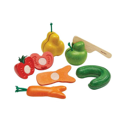 Set of mishapen toy fruits and vegetables with a knife on a white background