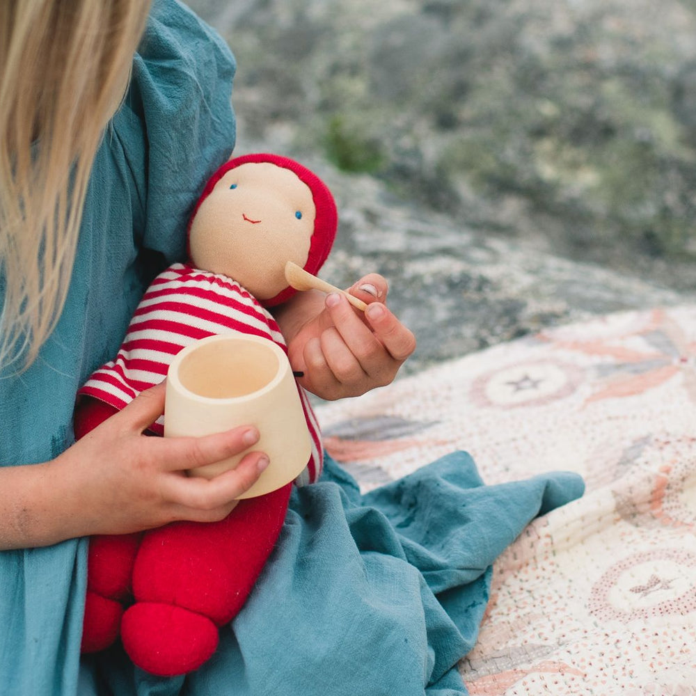 Girl feeding Keptin-Jr organic cotton doll