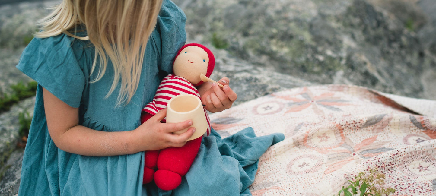 Girl feeding Keptin-Jr organic cotton doll