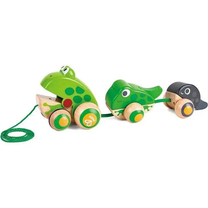 Wooden toy with three green frogs on a white background