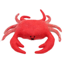 Felted red crab on a white surface