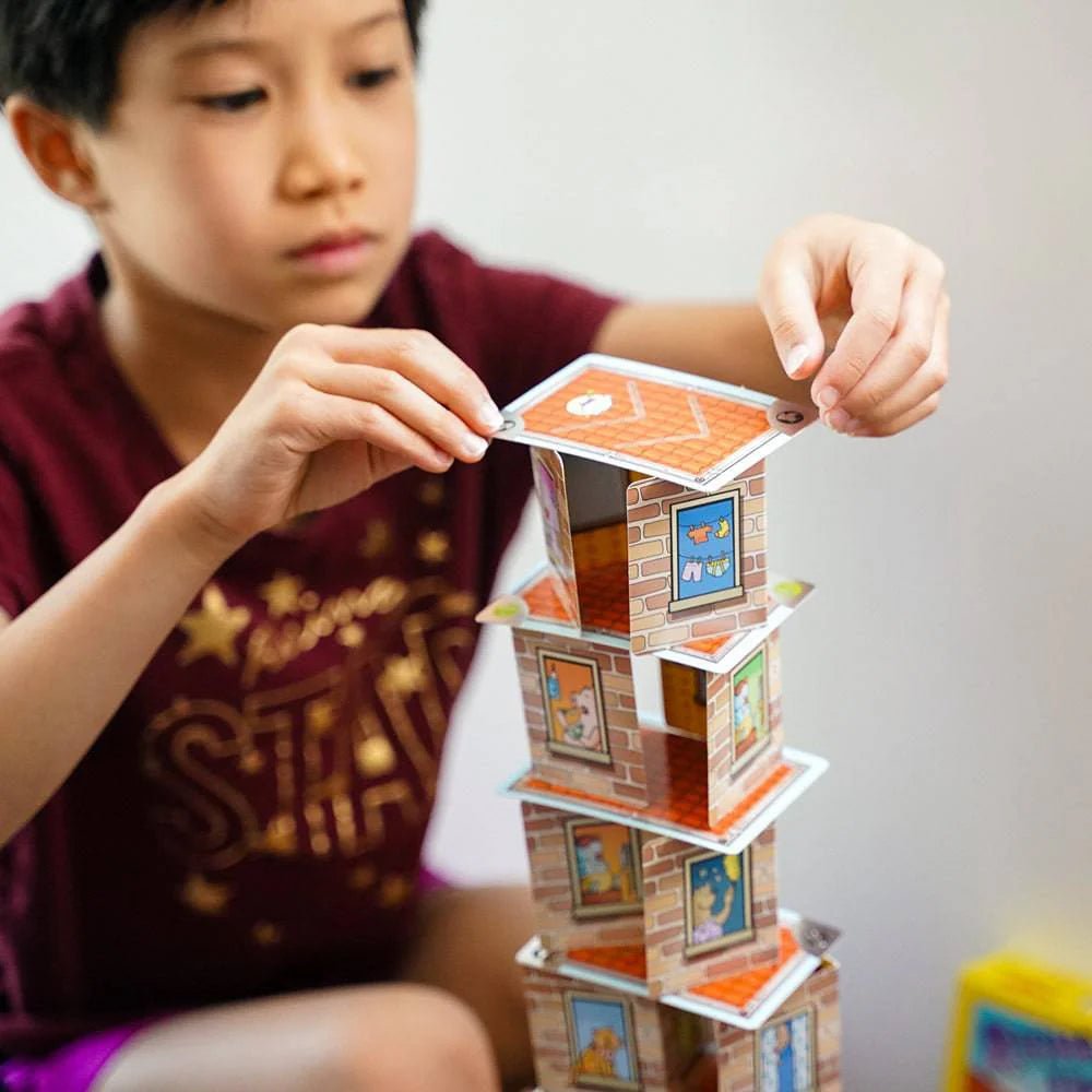 Child playing with a card tower game