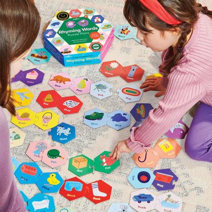 Two children playing with educational puzzle cards on a carpeted floor.