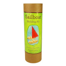 Sailboat building kit packaging with green label and brown cardboard tube on a white background