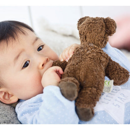 Baby holding brown baby bear