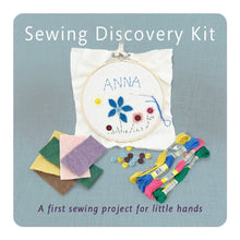 Sewing discovery kit with embroidery hoop, threads, and fabric squares on a blue background