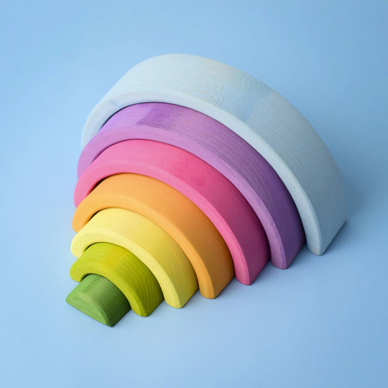 Colorful wooden rainbow toy on a light blue background